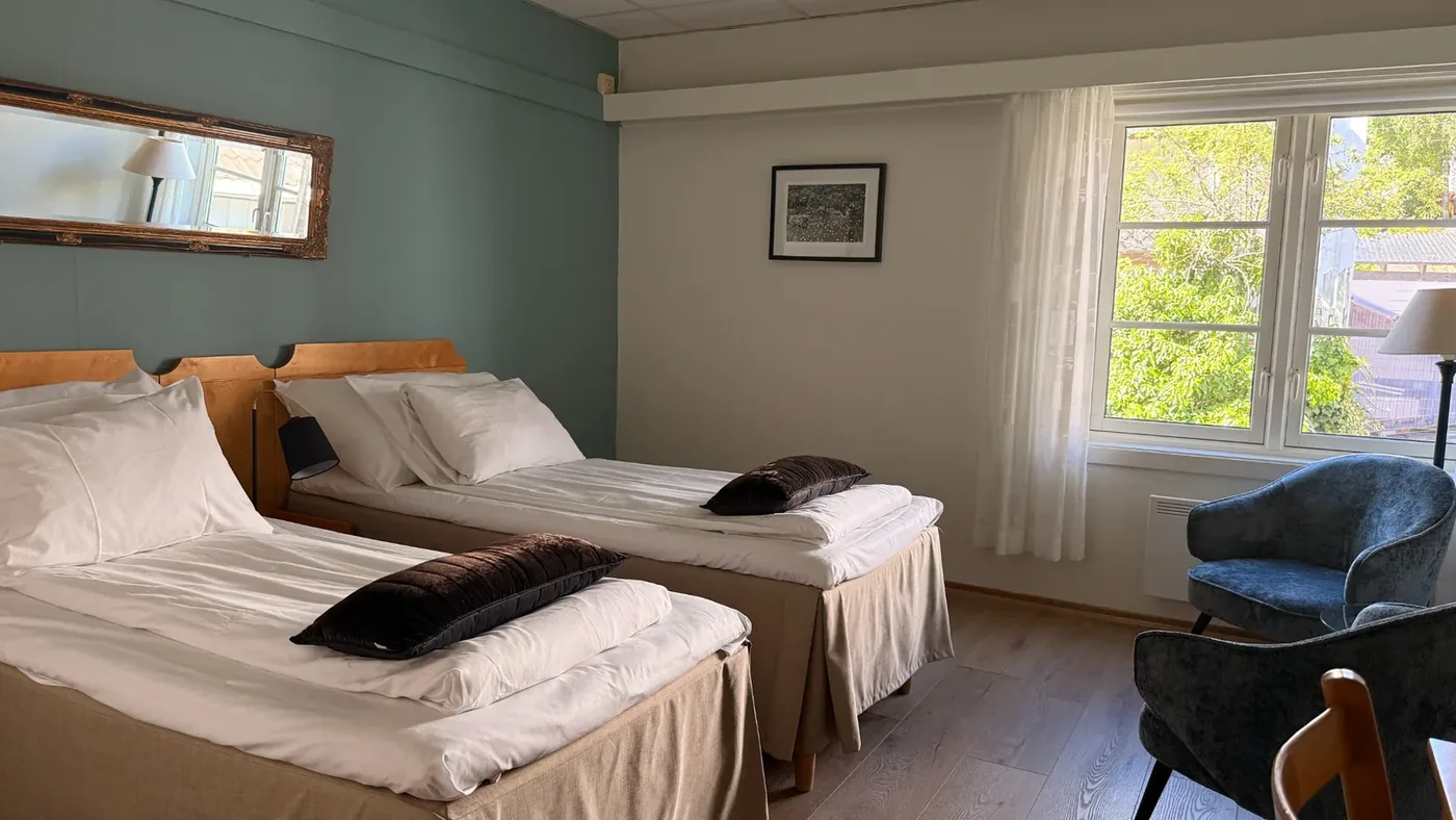 Twin rom med to separate senger og lyse tekstiler